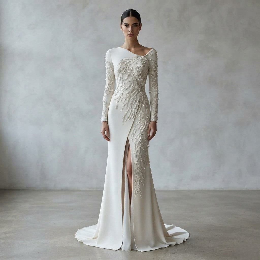 Vestido de novia de manga larga asimétrico con intrincados bordados florales de pedrería y abertura frontal en la falda de la Colección Mara.