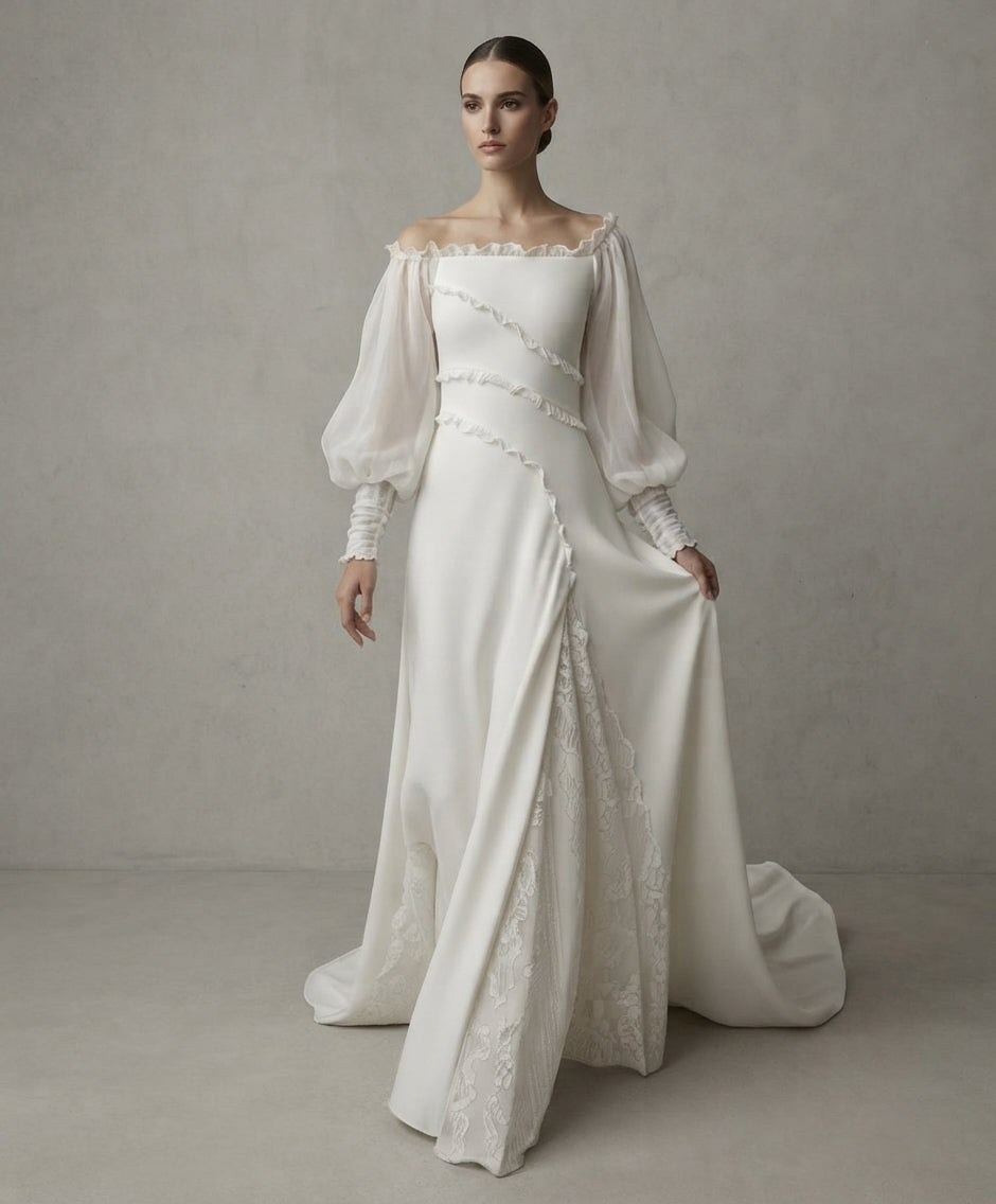 Vestido de novia romántico de hombros caídos con mangas abullonadas transparentes, detalles de volantes diagonales y falda fluida con panel de encaje lateral de la Colección Mara