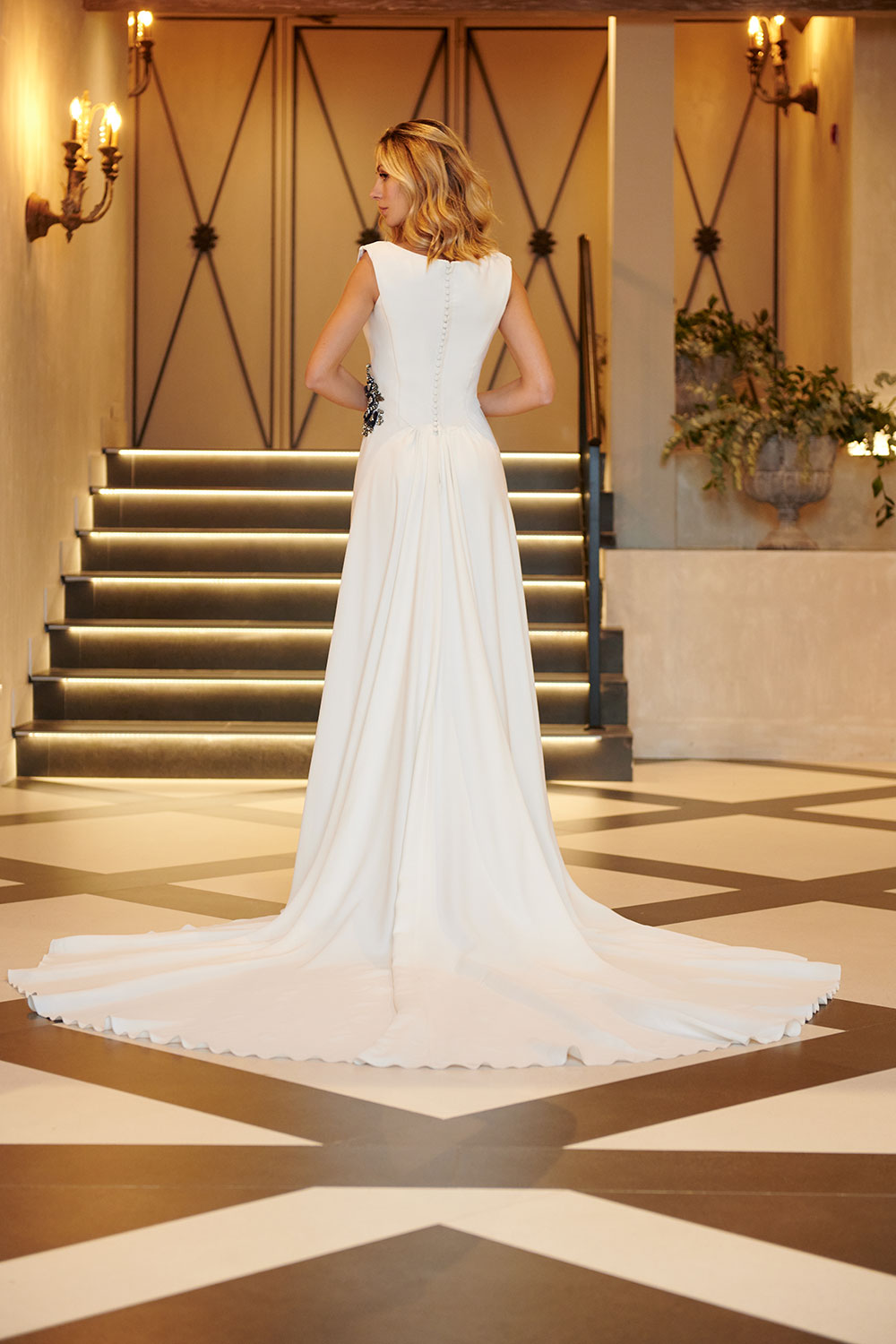 Creación bridal en blanco suave con detalles hechos a mano y silueta natural.