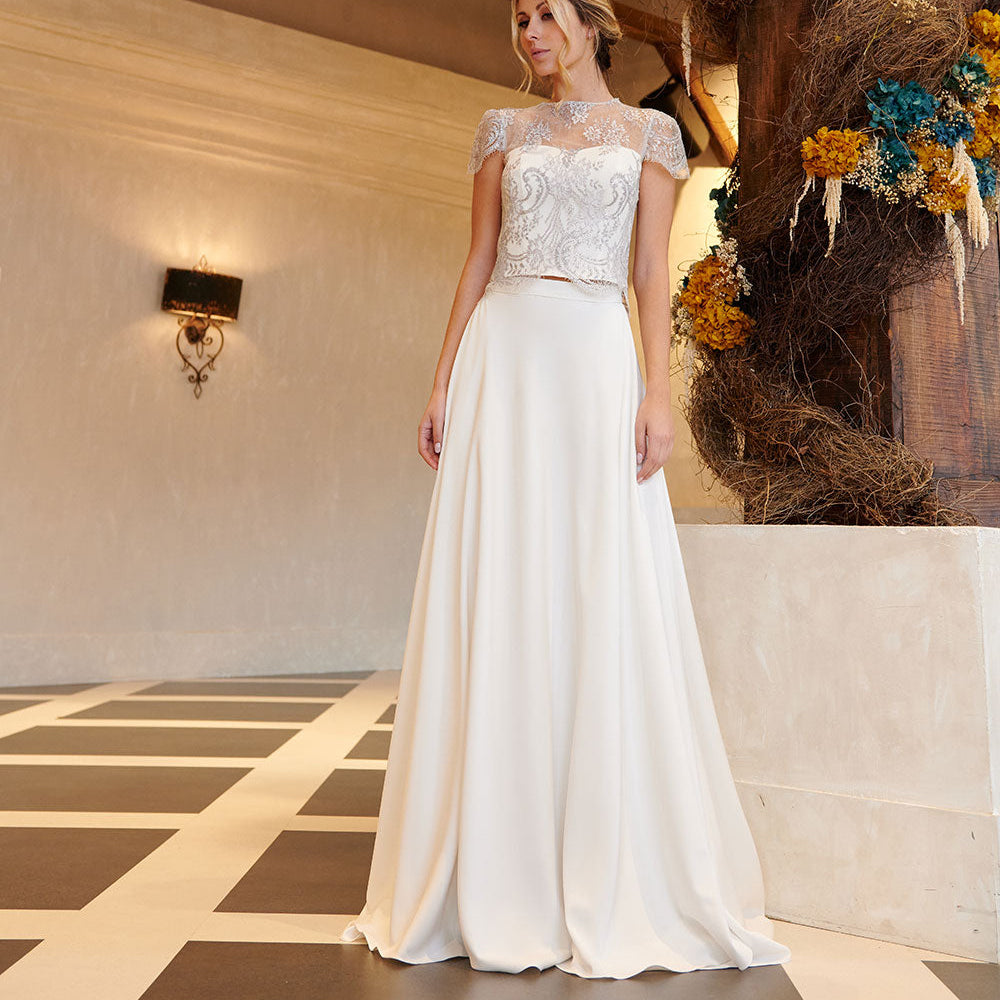 Diseño exclusivo Masum Karimi en blanco roto con líneas puras y feminidad silenciosa.